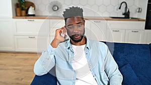 Headshot of smiling multiracial businessman in smart casual shirt talking on the smartphone