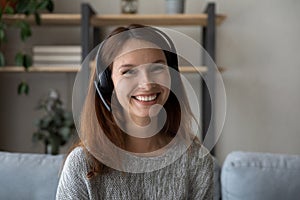 Headshot of smiling woman in headphones talk on video call