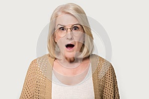 Headshot studio portrait aged amazed shocked woman isolated on grey