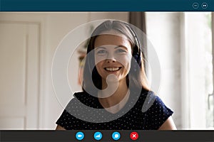 Headshot view of woman in earphones speak on video call