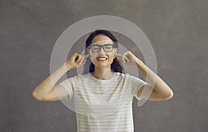 Headshot of woman closing ears with fingers to ignore loud noise or unsolicited advice photo