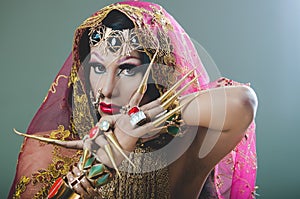 Headshot woman dressed in traditional hindu clothing, heavily decorated in gold and elegant veil, extremely long