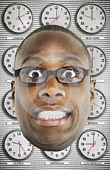 Headshot of worried man wearing glasses with various time zone clocks in background