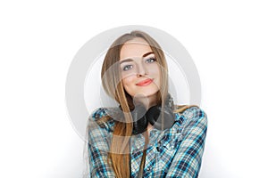 Headshot of a young adorable blonde woman in blue plaid shirt enjoying listening music to big professional dj headphones.