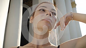 Headshot of young gorgeous ballerina moving in sunrays. Close-up portrait of elegant slim Caucasian redhead woman