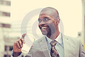 Headshot of young handsome man drinking outdoors on city background