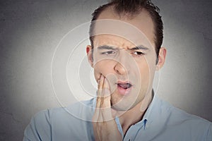 Headshot young man with sensitive tooth ache crown problem