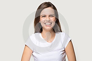 Headshot of young pretty brunette girl sincerely laughing at joke