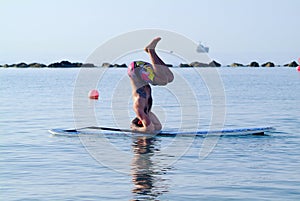 Headstand on stand up paddle board