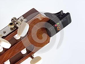 Headstock of the guitar with installed clip-on tuner, that shows