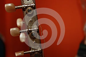 Headstock with mechanics of a classical guitar with orange background