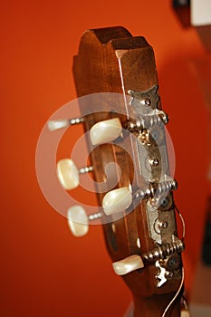 Headstock with mechanics of a classical guitar with orange background