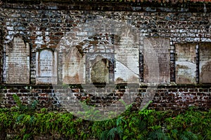 Headstones on brick wall