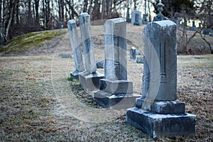 Headstones at an old delapidated looking graveyard on a gray gloomy day in Upstate New York