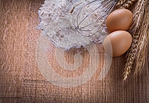 Heaf of four eggs corolla wheat ears on wooden