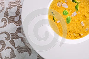 Healhty homemade pumpkin soup with herb on white plate, product photography for restaurant and gastronomy