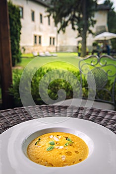 Healhty homemade pumpkin soup with herb on white plate, product photography for restaurant and gastronomy