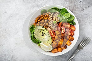 healhty vegan lunch bowl. Avocado, quinoa, sweet potato, tomato, spinach and chickpeas vegetables salad