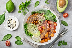 healhty vegan lunch bowl. Avocado, quinoa, sweet potato, tomato, spinach and chickpeas vegetables salad