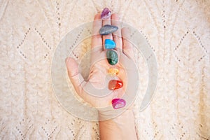 Healing crystals on female hand background, seven chakra stones