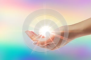 Healing hands with bright sunburst on rainbow background