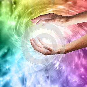 Healing hands with vibrant rainbow vortex