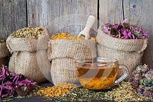 Healing herbs in hessian bags and healthy tea cup