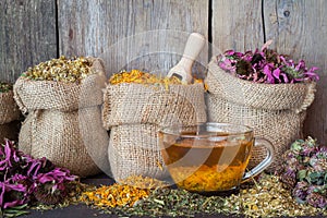 Healing herbs in hessian bags and healthy tea cup photo