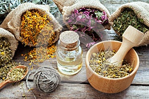 Healing herbs in hessian bags, mortar with chamomile