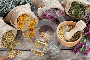 Healing herbs in hessian bags, wooden mortar with chamomile