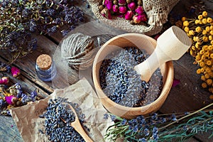 Healing herbs, wooden mortar with lavender, bottles of tincture