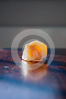 Healing orange calcite crystal on a table. Gemstones are full of healing energy and good vibes