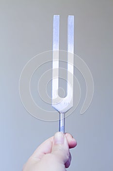 Healing tuning fork and crystal stone on table .