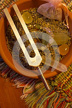 Healing tuning fork and crystal stone on table .