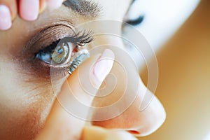 Health. Beautiful Young Girl Holds On A Finger Contact Lens. Portrait of a Beautiful Woman with Green Eyes. Healthy Look