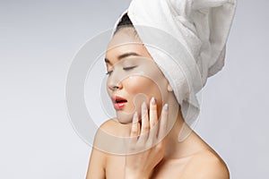 Health and beauty concept - Attractive asian woman applying cream on her skin, isolated on white.