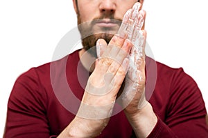 Health beauty and skin care concept. Closeup young bearded man with beard soap or shampoo on his hand for washing beard