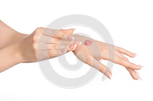 Health and body care theme: beautiful female hand with pink scrub cream on a white background isolated