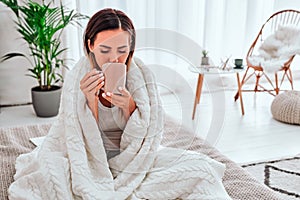 Health Care. Closeup of beautiful ill woman with headache, sore throat and fever covered in blanket feeling sick