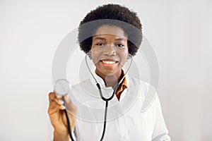 Health care concept, medical insurance. Portrait of beautiful smiling female african american doctor standing in medical