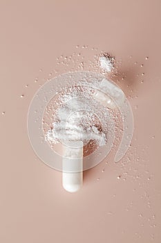 Health care concept. White medical open capsule with powder inside on beige background. copy space