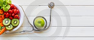 Health Care. Fresh vegetable salad and green apple with medical stethoscope for diet