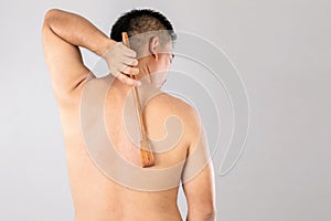 Health care or Itchy or Tinea Cruris concept : Portrait of people using Scratch wood stick to Scratching on his back side. Studio