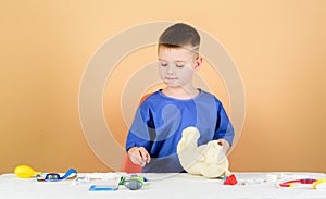 Health care. Kid little doctor busy sit table with medical tools. Medicine concept. Medical procedures for teddy bear