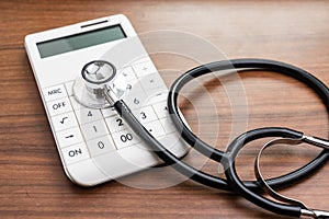 Health care and medical cost expense calculation or financial analysis and saving status concept, doctor stethoscope put on modern