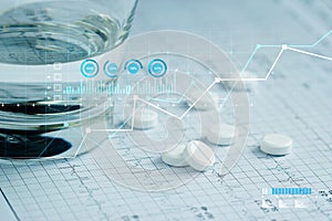 Health care and Medical, Patients` pills and water glass placed on a heartbeat report paper And a graph of the growth of medical