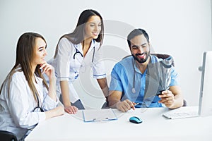 Health Care. Medical Team Examining X-ray Report in Corridor. Me