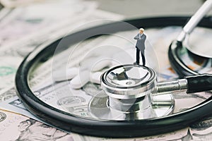 Health care, pharmaceutical and medical industry business concept, miniature businessman standing on stethoscope and white tablet