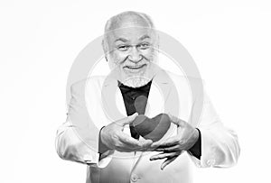 Health care. Preventing heart attack. Senior bald head bearded man holding red toy heart in hands. Healthy life. Mature