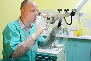 Health care professional looking through microscope